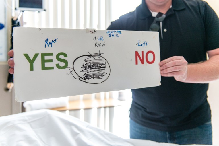 Jeremy Wilson, 40, communicates with his father using a makeshift board at St. John’s Pleasant Valley Hospital in Camarillo, Calif., on Wednesday, February 24, 2016. His father, John Wilson, can’t speak but can communicate using his eyes. (Heidi de Marco/KHN)