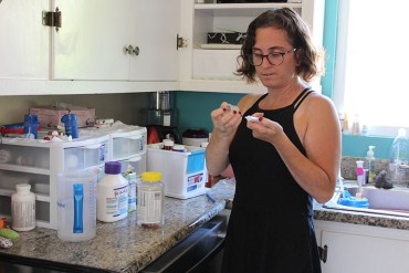 Elana Ford, 37, goes through her son’s medication at their El Cerrito, Calif. home on Aug. 4, 2016. (Ana B. Ibarra/California Healthline)