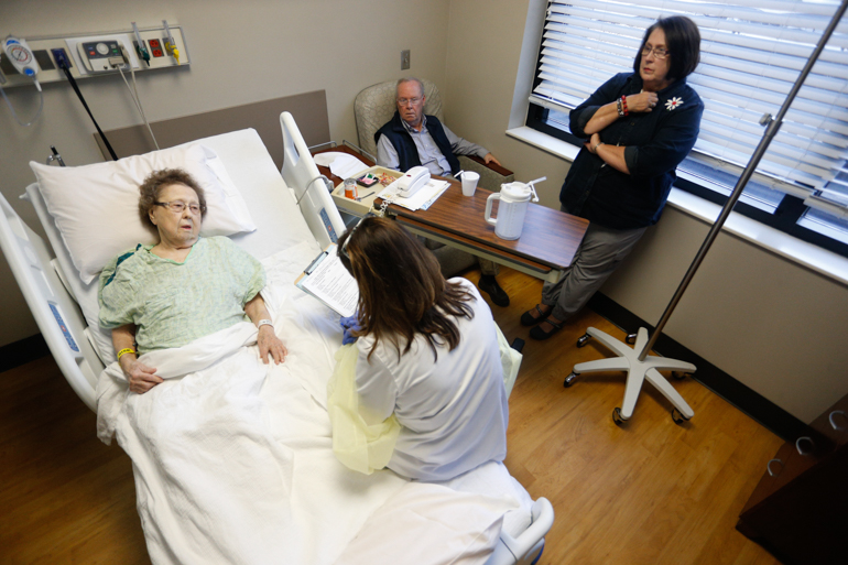 Thelma Atkins, 92, talks to Terri Middlebrooks, a nurse who manages the geriatric unit at UAB Hospital-Highlands. Atkins’ daughter and son -in-law listen in. Middlebrooks says that “patients walk in the door of a hospital and think it’s OK to stay in a bed. It’s not.” (Hal Yeager for California Healthline)