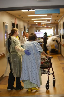 Thelma Atkins, 92, gets help walking around the geriatric unit at UAB Hospital-Highlands. (Hal Yeager for California Healthline)