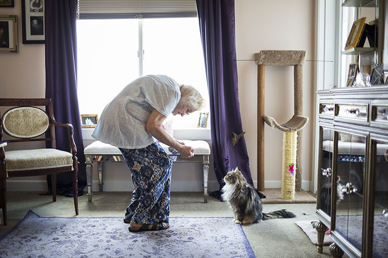 Kathy Baron with Munchkin. Baron was left disabled by breast cancer and nerve pain. InnovAge has made it possible for her to stay in her home. “I would rather be dead than go into a nursing home,” she said. (Nick Cote for The New York Times and KHN)