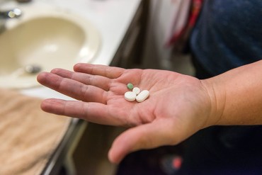 Rosemary Navarro takes her nightly dose of medication and supplements. (Heidi de Marco/California Healthline)