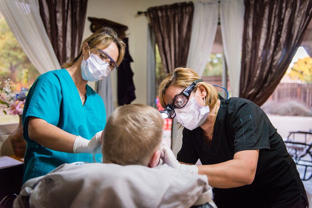 Dental hygienist Gita Aminloo cleans a patient’s teeth.