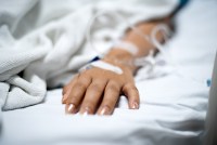 Girl patient with IV drip medicine attached in hospital