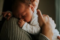 Mother holding her baby indoors