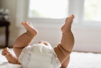 baby laying on floor with diaper