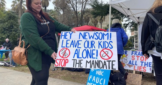 Jessica Holloway, a vaccine protester, holds a sign at an anti-vaccine rally at the California Capitol in early January.
