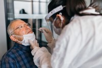 An elderly man receives a covid test.