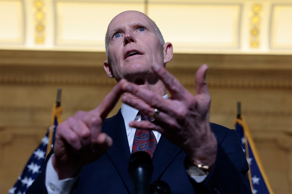 Sen. Rick Scott counts on his fingers while speaking during a press conference on Capitol Hill in Washington.