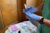 A closeup photo of Dr. Herring's gloved hands shows a syringe of Sublocade.