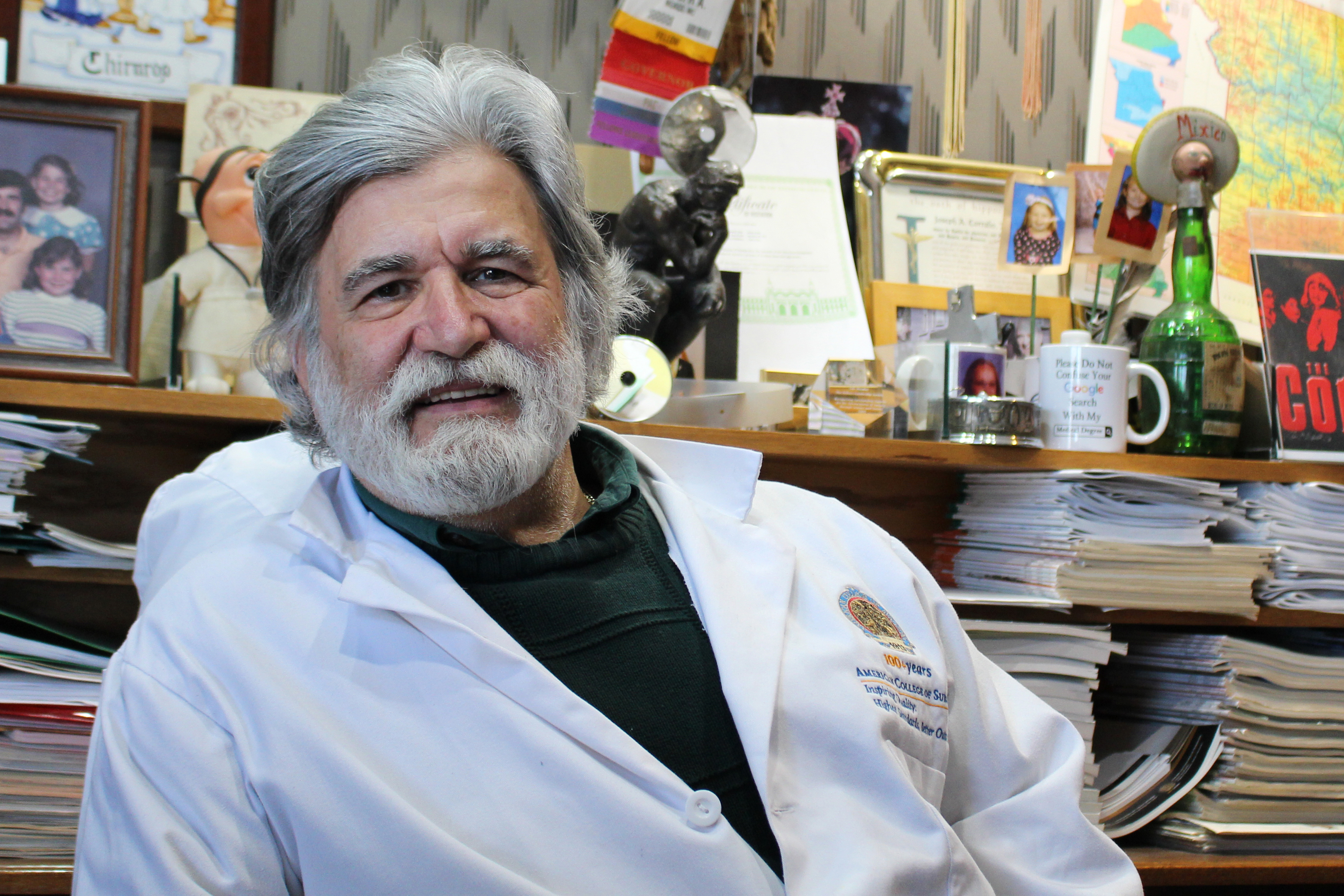 Dr. Joe Corrado is seen posing for a portrait while wearing a white lab coat.