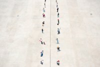 A photo illustration shows two rows of people standing on separated zones, divided in the middle with a dashed line.