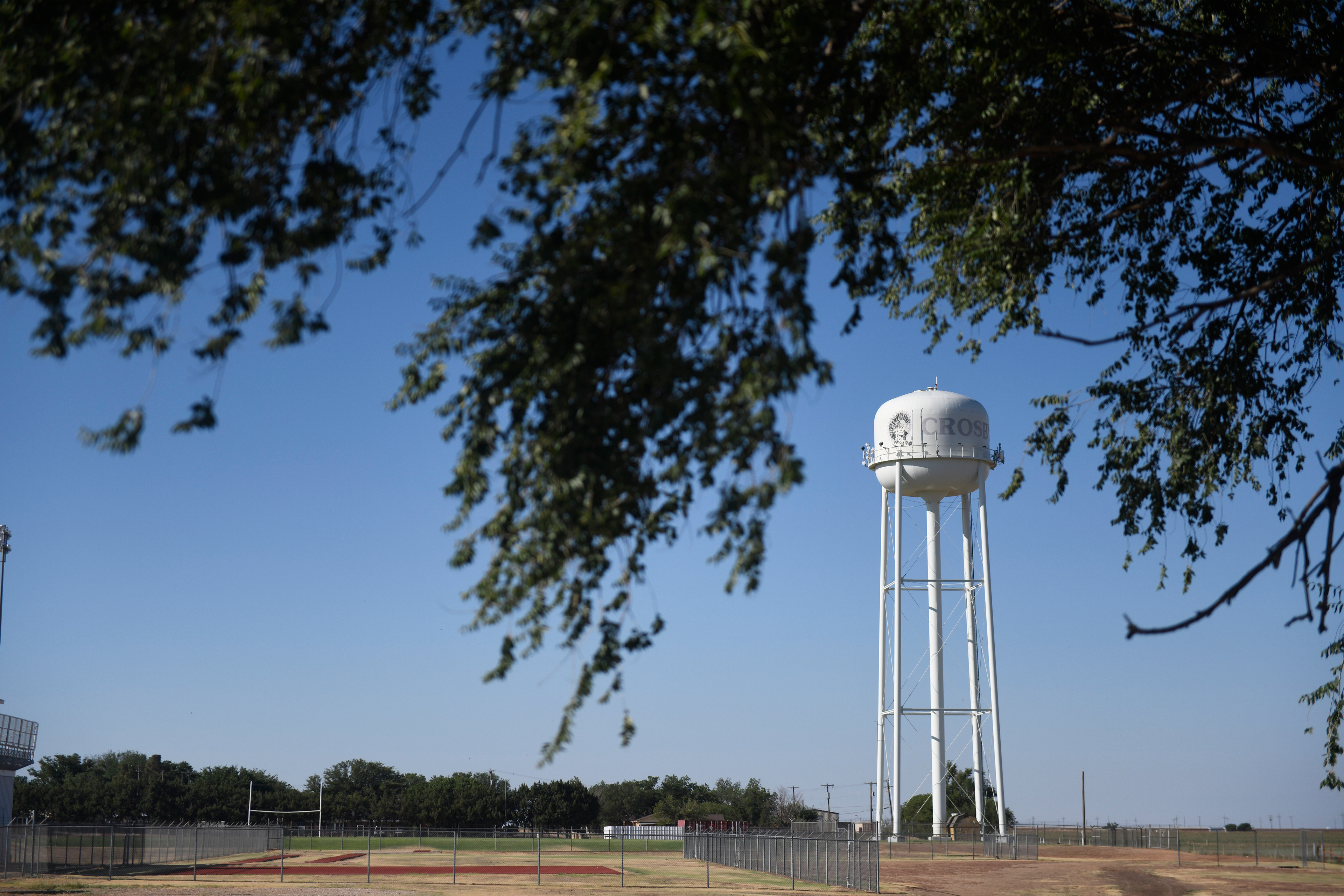 A photo shows Crosbyton's water tower in the distance framed by trees in the foreground.