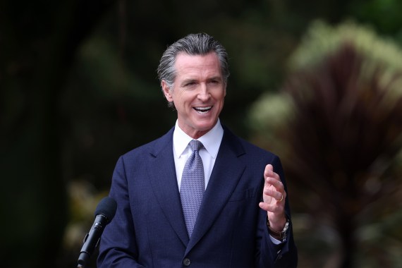 A photo shows Gavin Newsom speaking at a press conference.