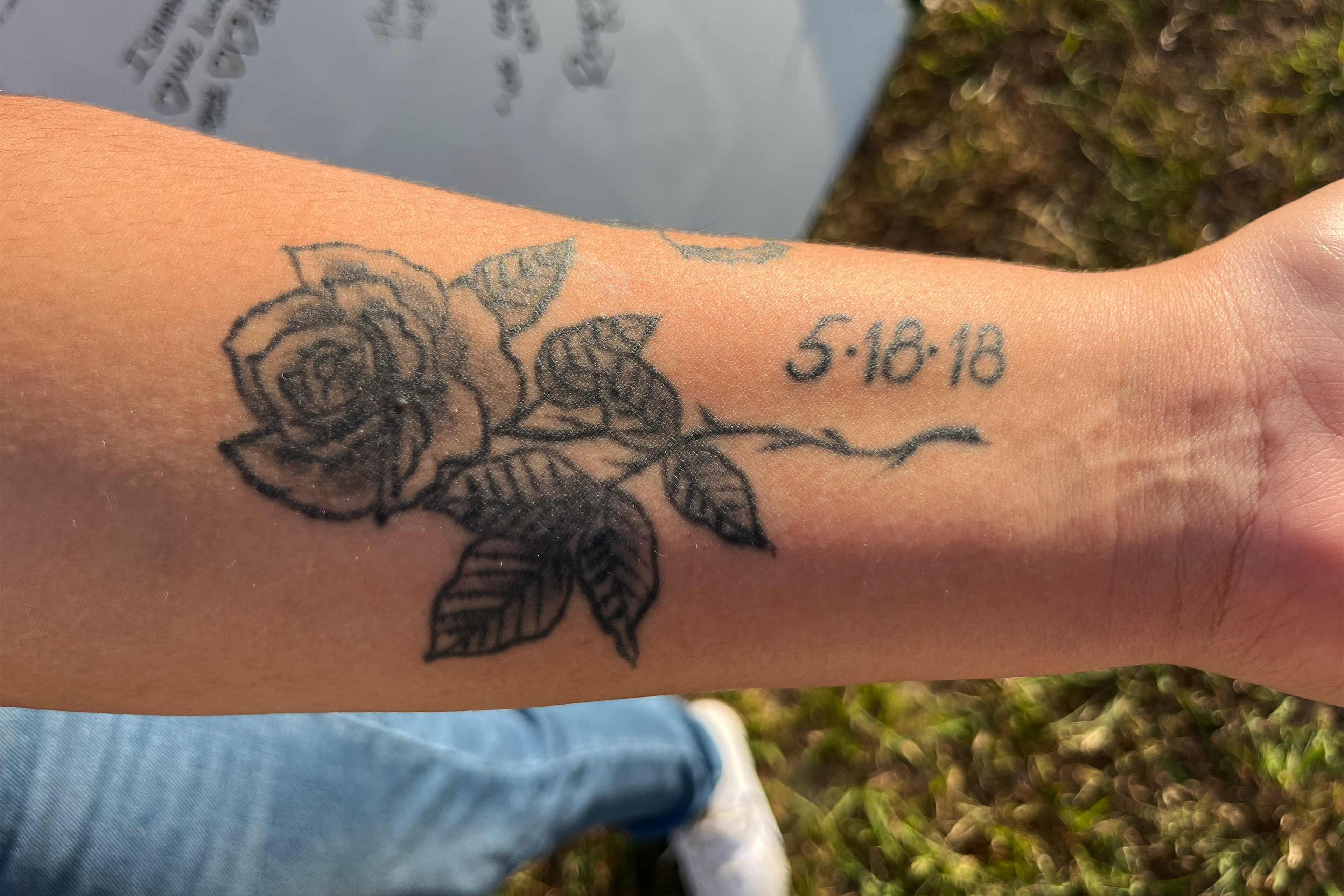 A photo of Reagan Gaona's wrist shows a black and gray rose tattoo with a date next to it: May 18, 2018.