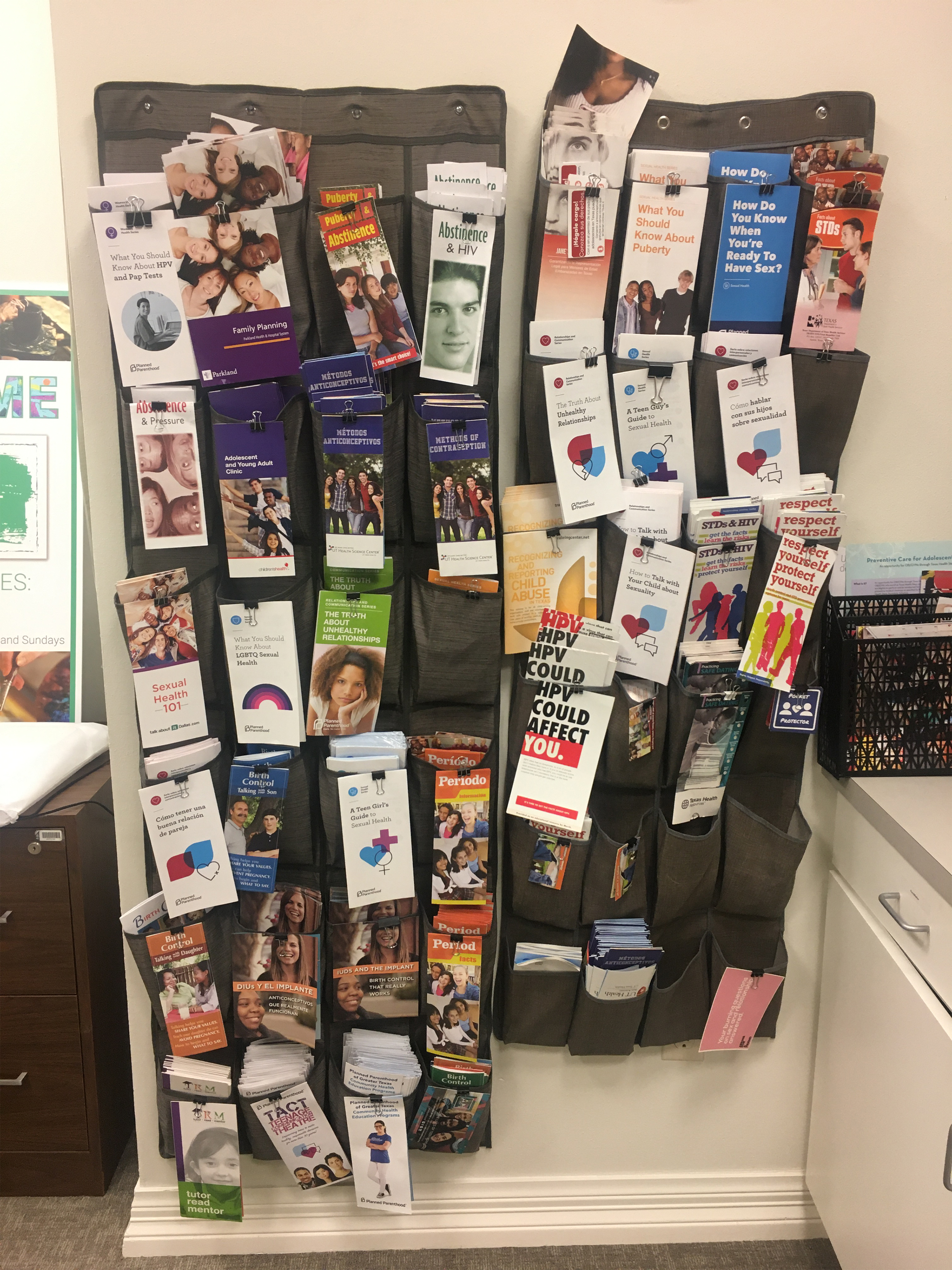A photo shows a wall filled with pamphlets.