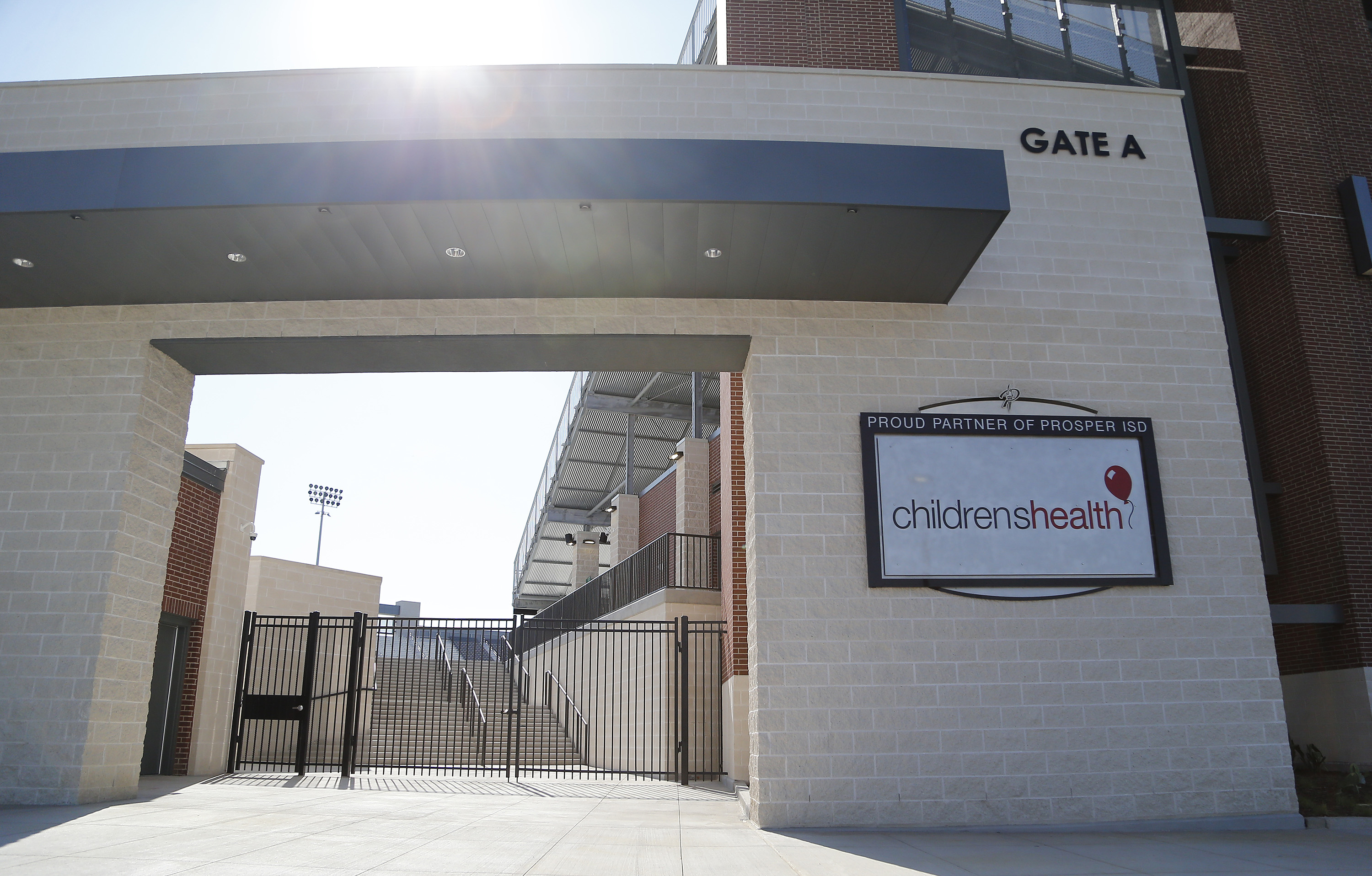 A photo shows the exterior of Children's Health Stadium with a sign bearing the hospital system's logo on a wall.