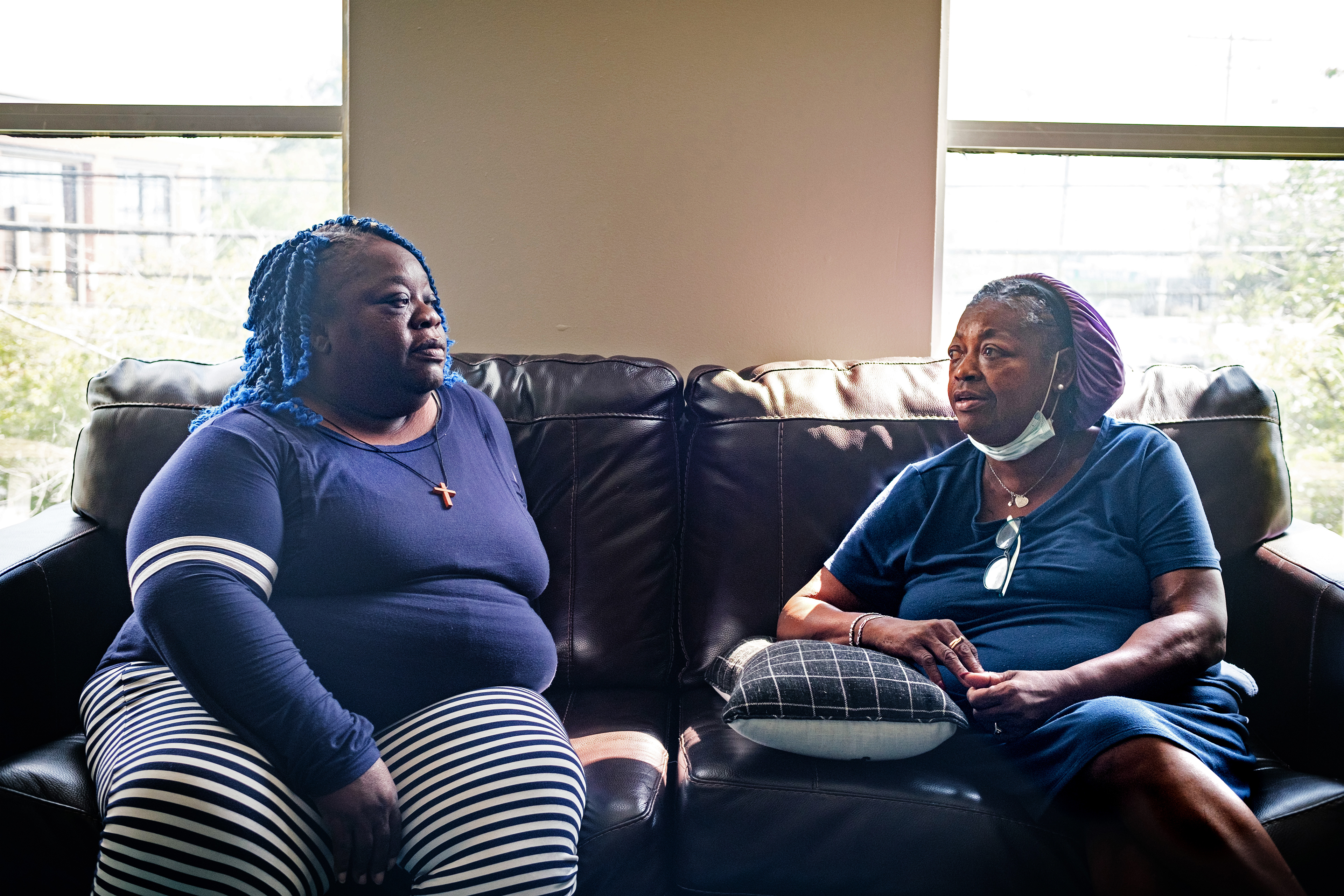 A photo shows Delisa Williams and Margaret Davis sitting on a couch in front of window, conversing.