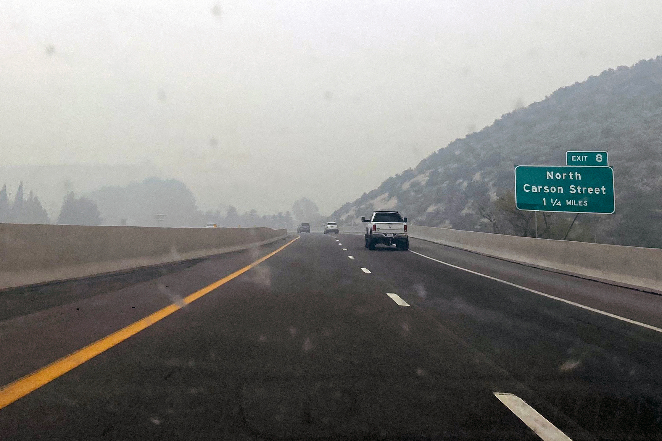 A photo shows smoke filling the air down a stretch of road in Gardnerville, Nevada.