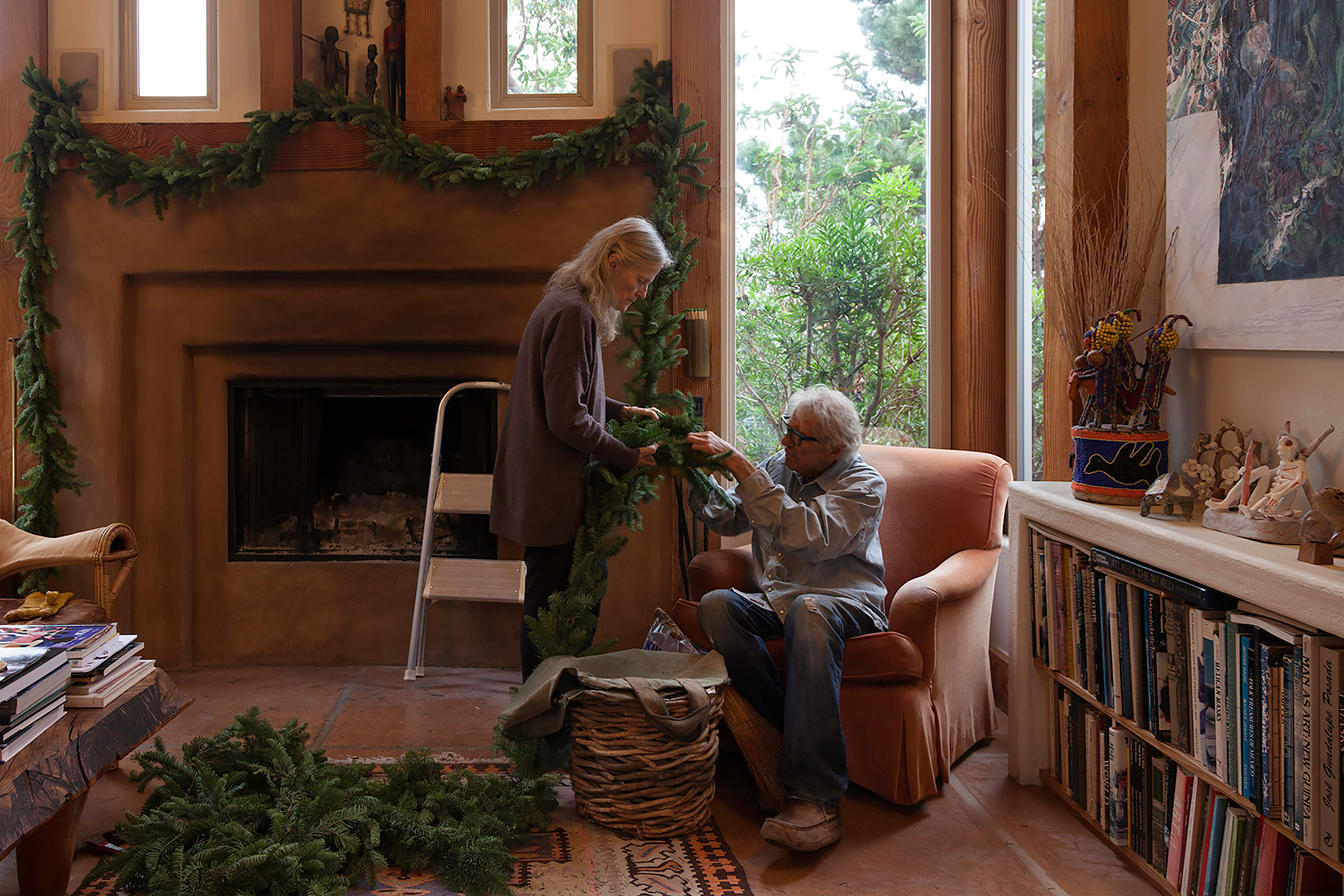 A photo shows Marna Clarke and Igor Sazevich together, hanging a garland around their house.