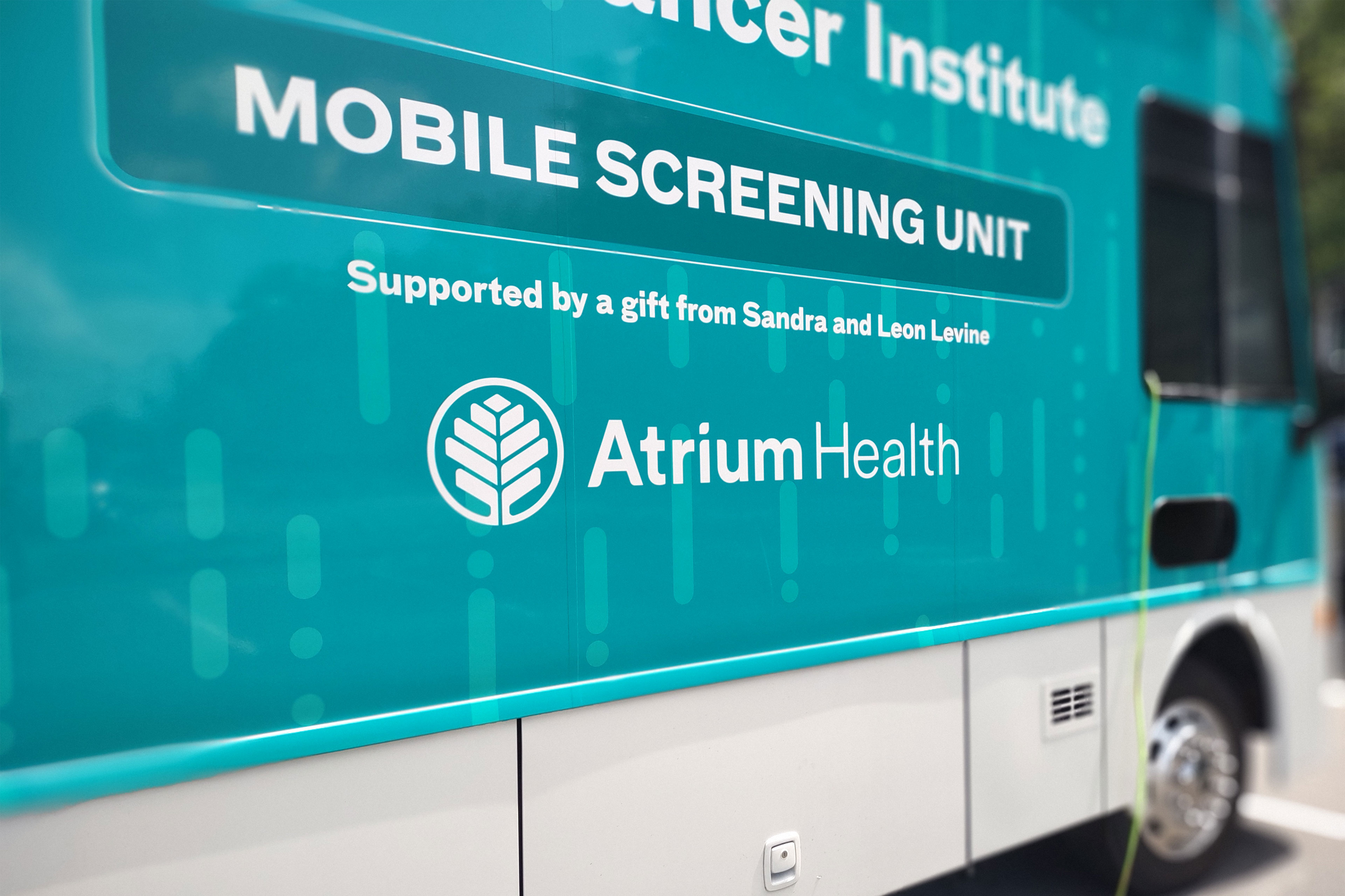 A photo shows the outside of a green bus with the Atrium Health logo and text that reads, "Mobile screening unit."