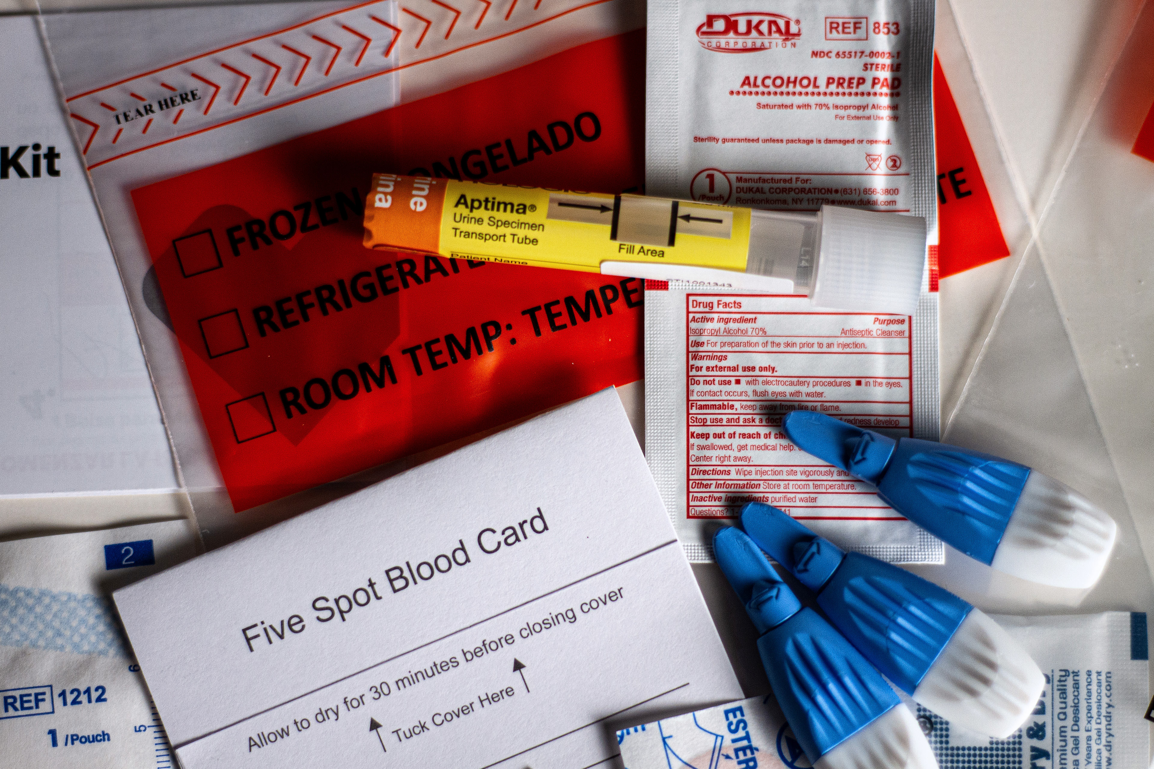A photo shows the contents of a home STD test spread across a counter.