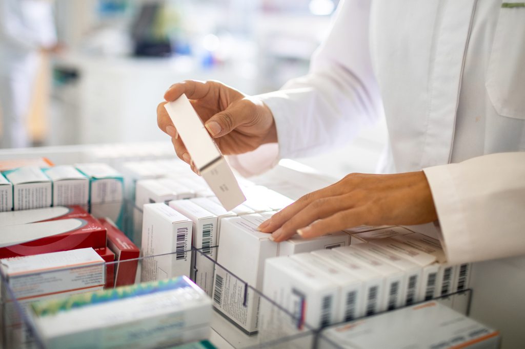 A photo shows a pharmacist organizing a medicine drawer.