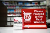 A photo shows a box of naloxone on the counter inside a Walgreens pharmacy.