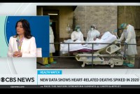 A still from a CBS News segment shows Dr. Céline Gounder speaking next to an image of hospital workers. Text on the screen reads, "New data shows heart-related deaths spiked in 2020."