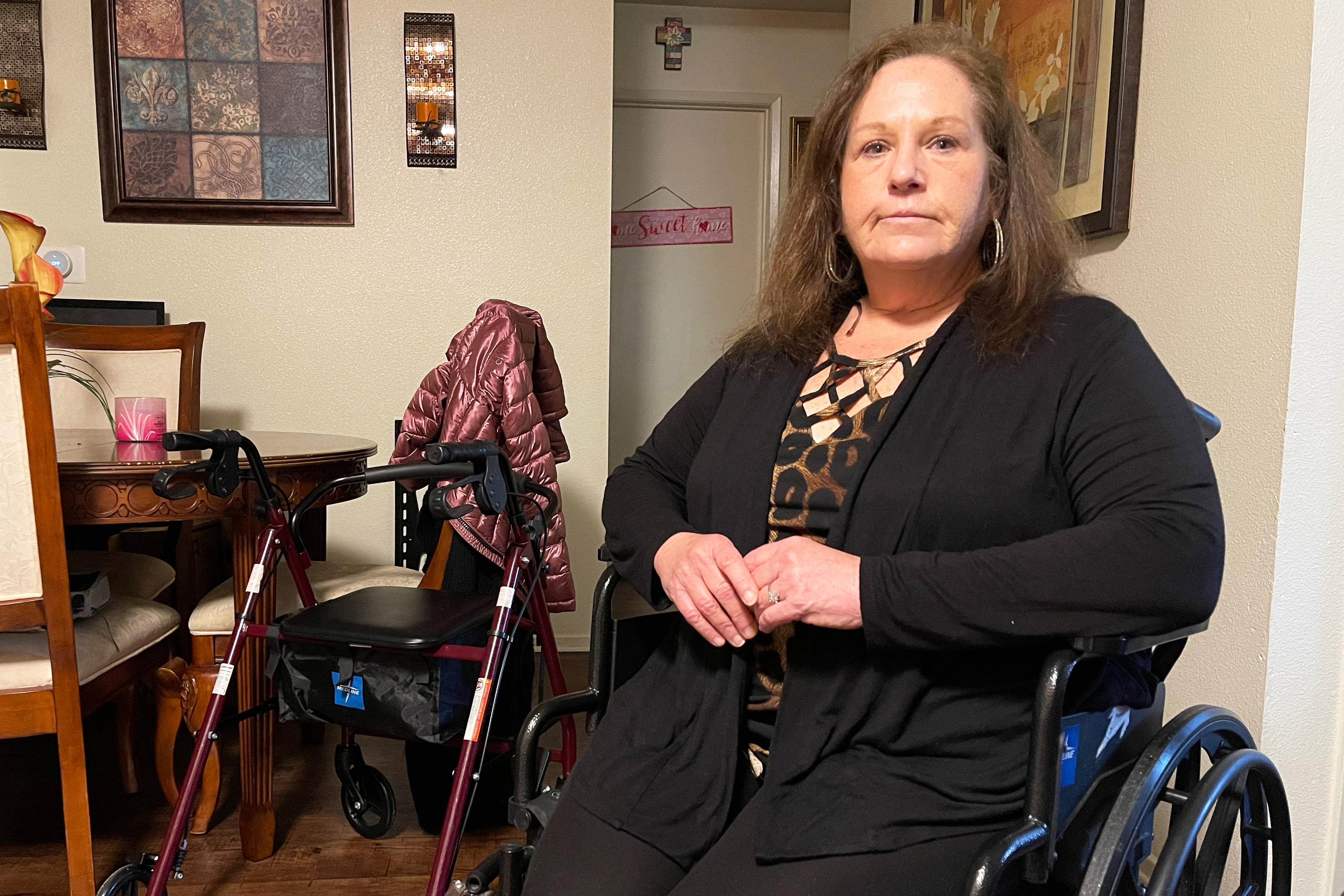 A photo of a woman in a wheelchair sitting for a portrait indoors.