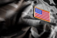 A photo of an American flag patch on camoflage.