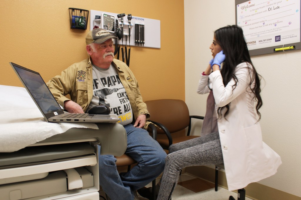 A photo of a doctor talking to a patient in an exam room.