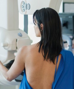 A photo of a woman receiving a mammogram.