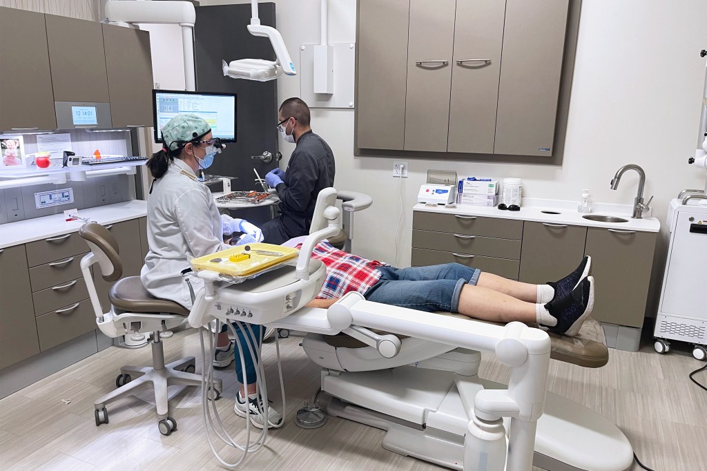 A photo of a dental therapist working on a patient.