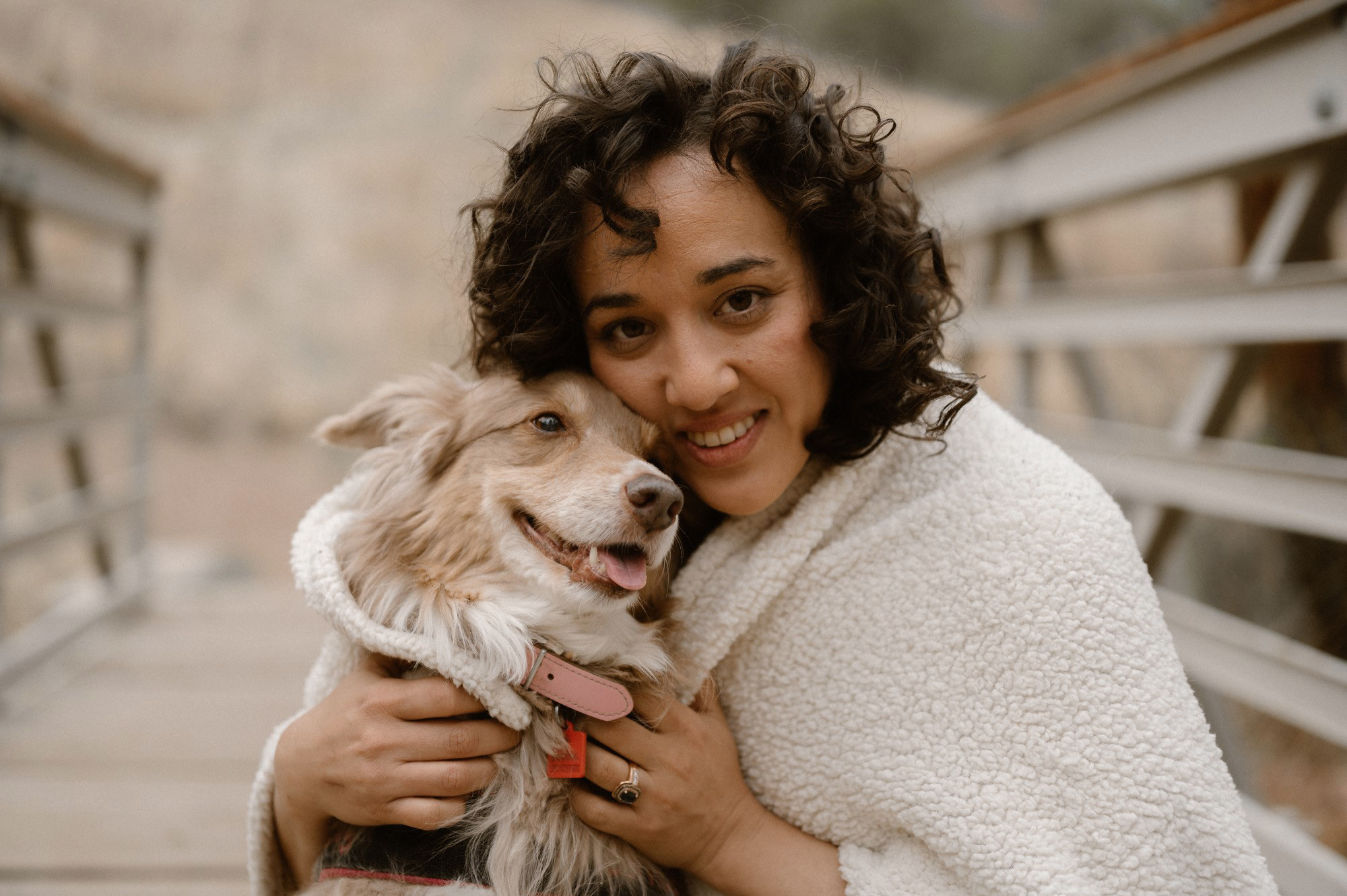 A photo of Mariana Marquez-Farmer posing for a portrait outside with her dog.
