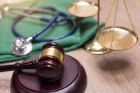 A photo of a gavel next to a stethoscope and scales of justice.