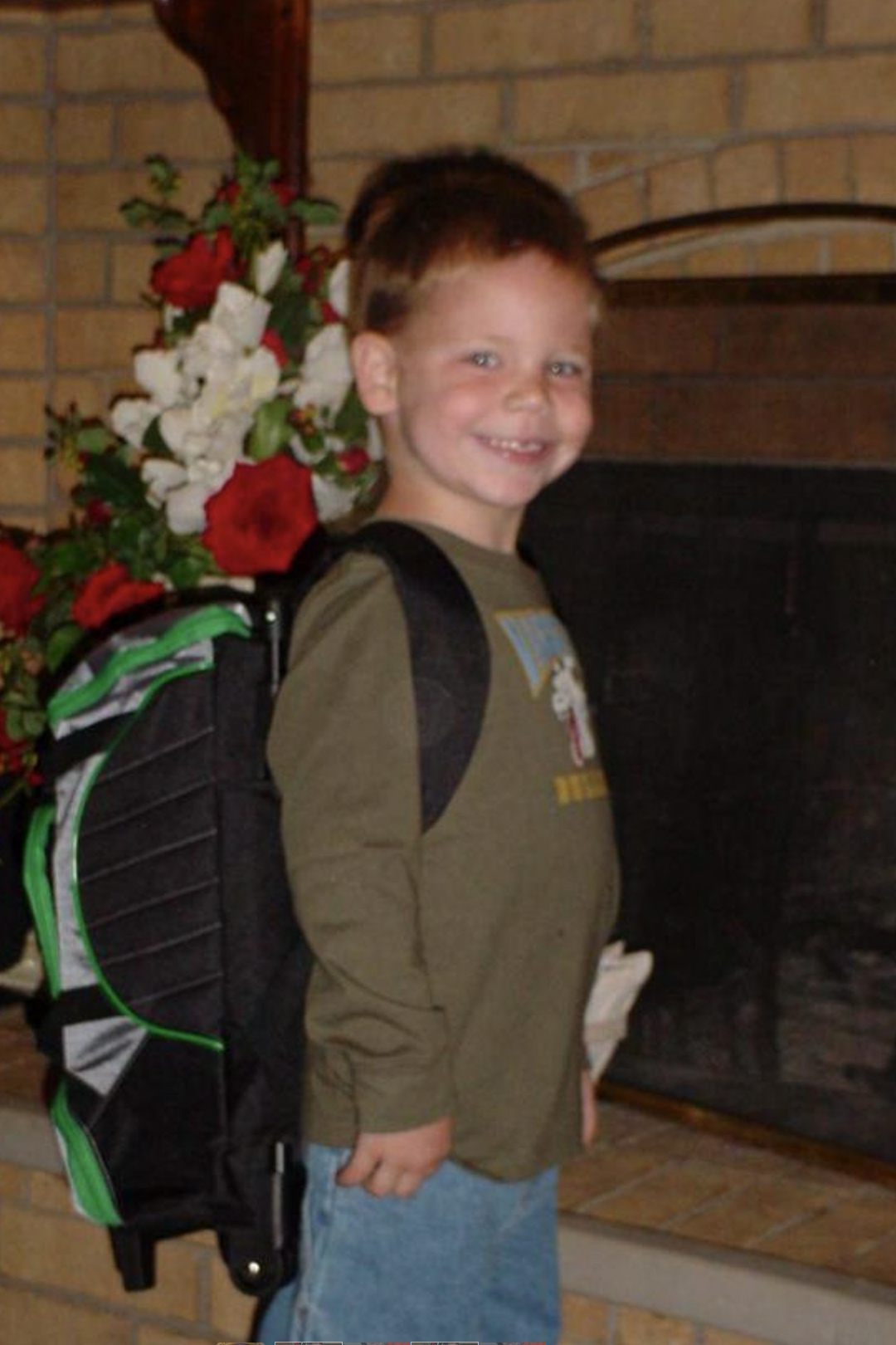 A photograph of elementary school student, Montana Lance. He is wearing a school backpack and smiling at the camera.