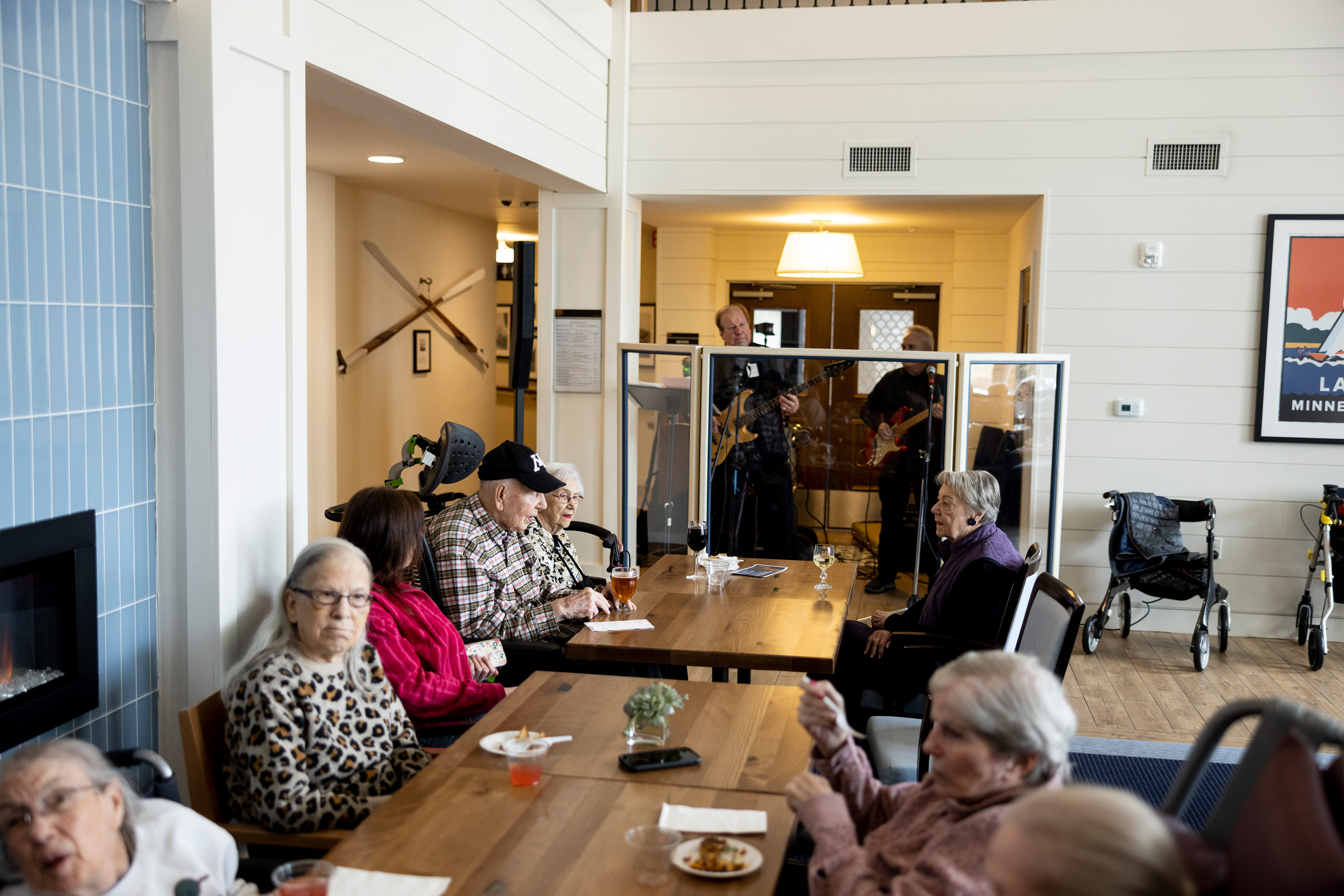 A photo of elderly residents of an assisted living facility sitting around a table and chatting.