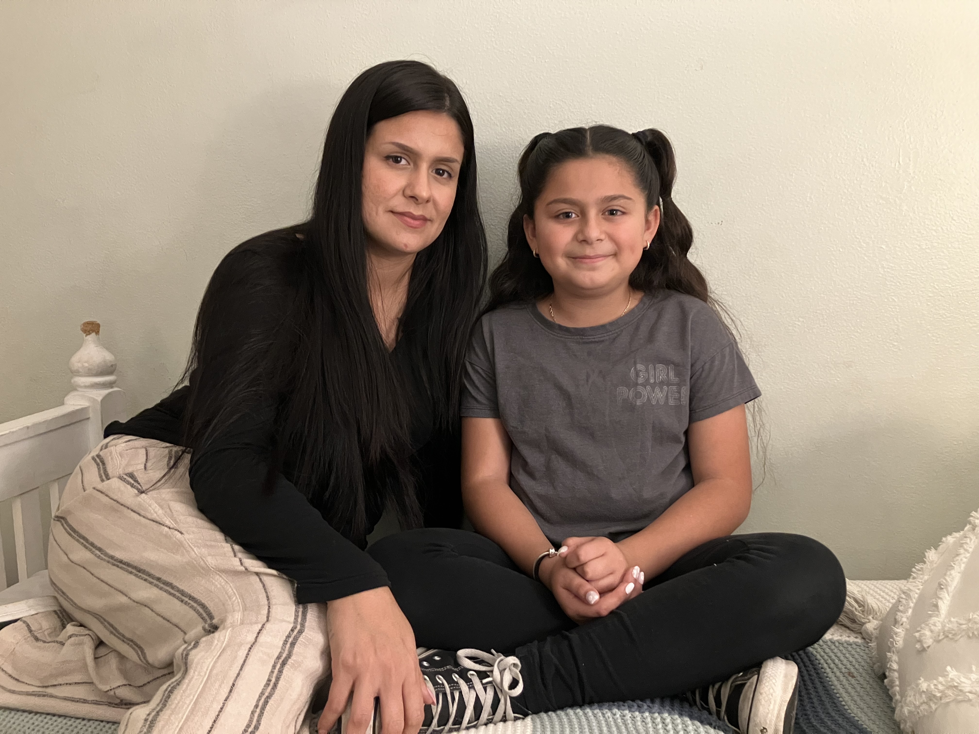 Anjelah Salazar sits on her bed beside  her mom, Rosanna Chavira. 