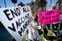 A photo of protesters holding signs that read, "End all vaccine mandates," and "Don't experiment on our kids."