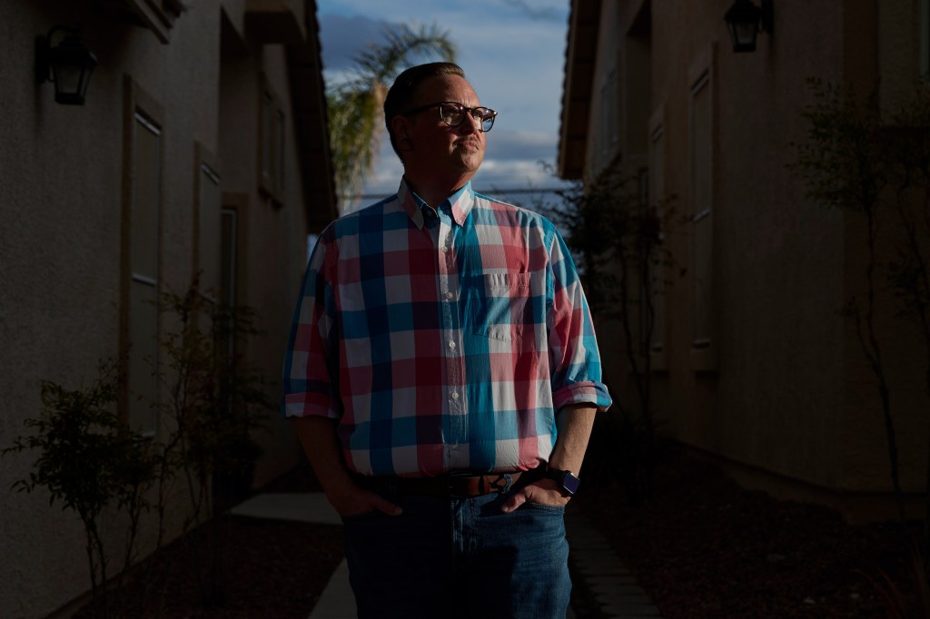 A photo of a man standing outside for a portrait with dramatic lighting.