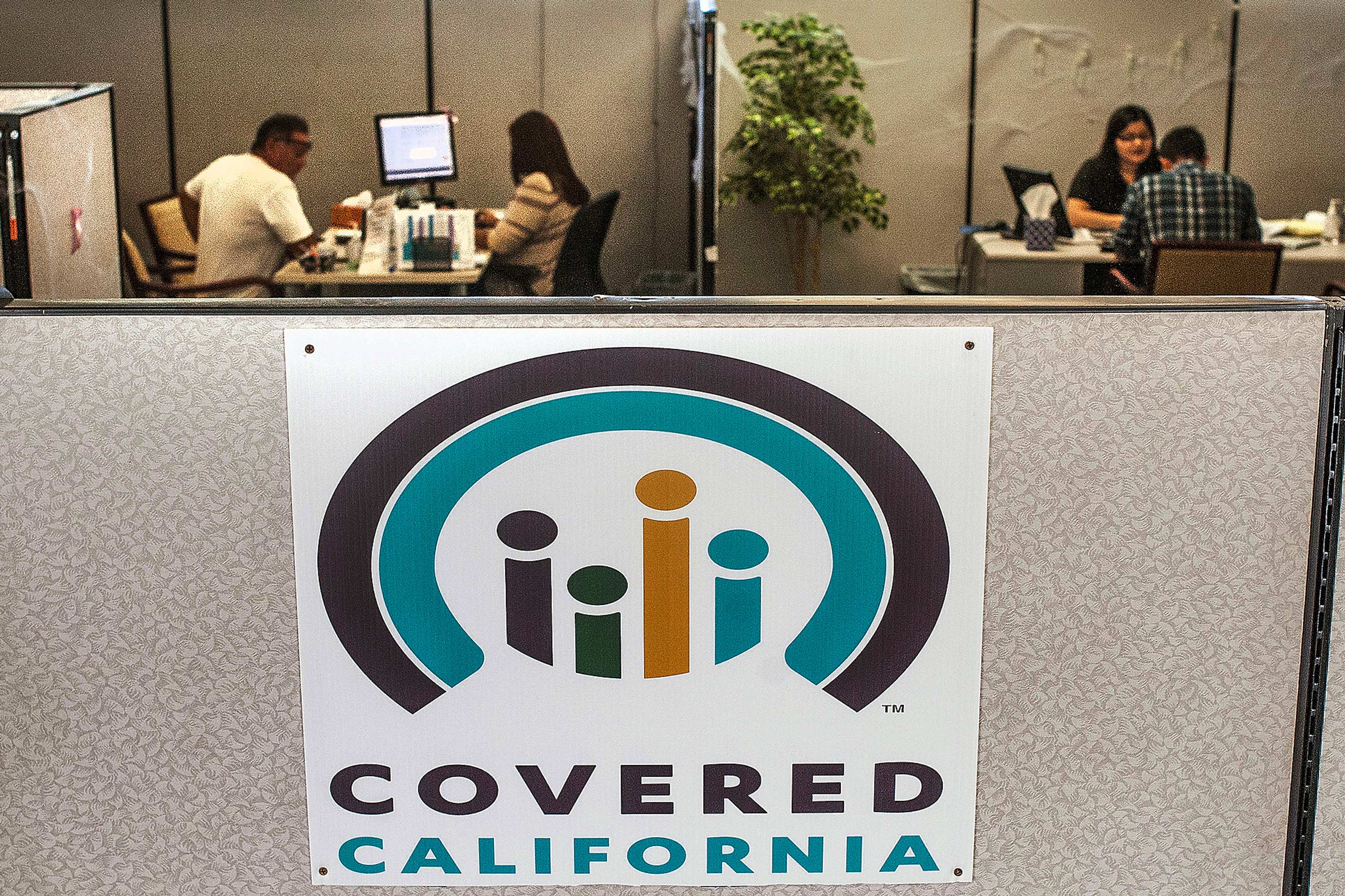 A photo of the "Covered California" logo on an office cubicle interior.
