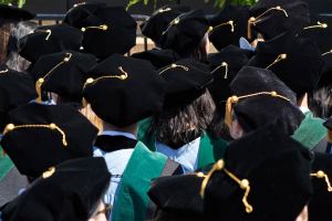 A photo of medical students at a graduation ceremony. They are seen from behind with their graduation tams and tassels facing the camera.