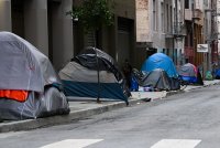 A photo of a row of tents set up in a homeless encampment.