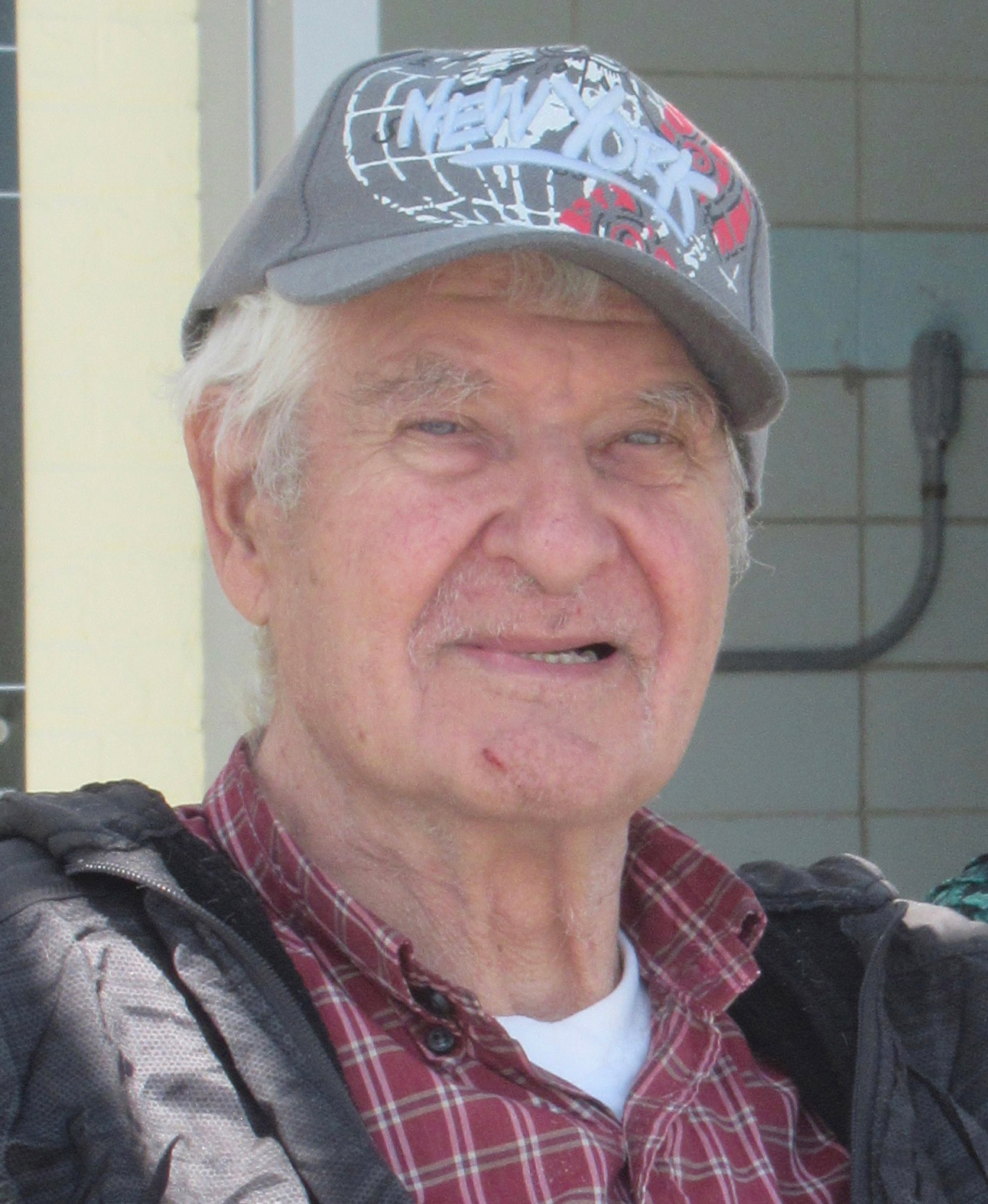 A photo of an older man smiling for a photo outside.