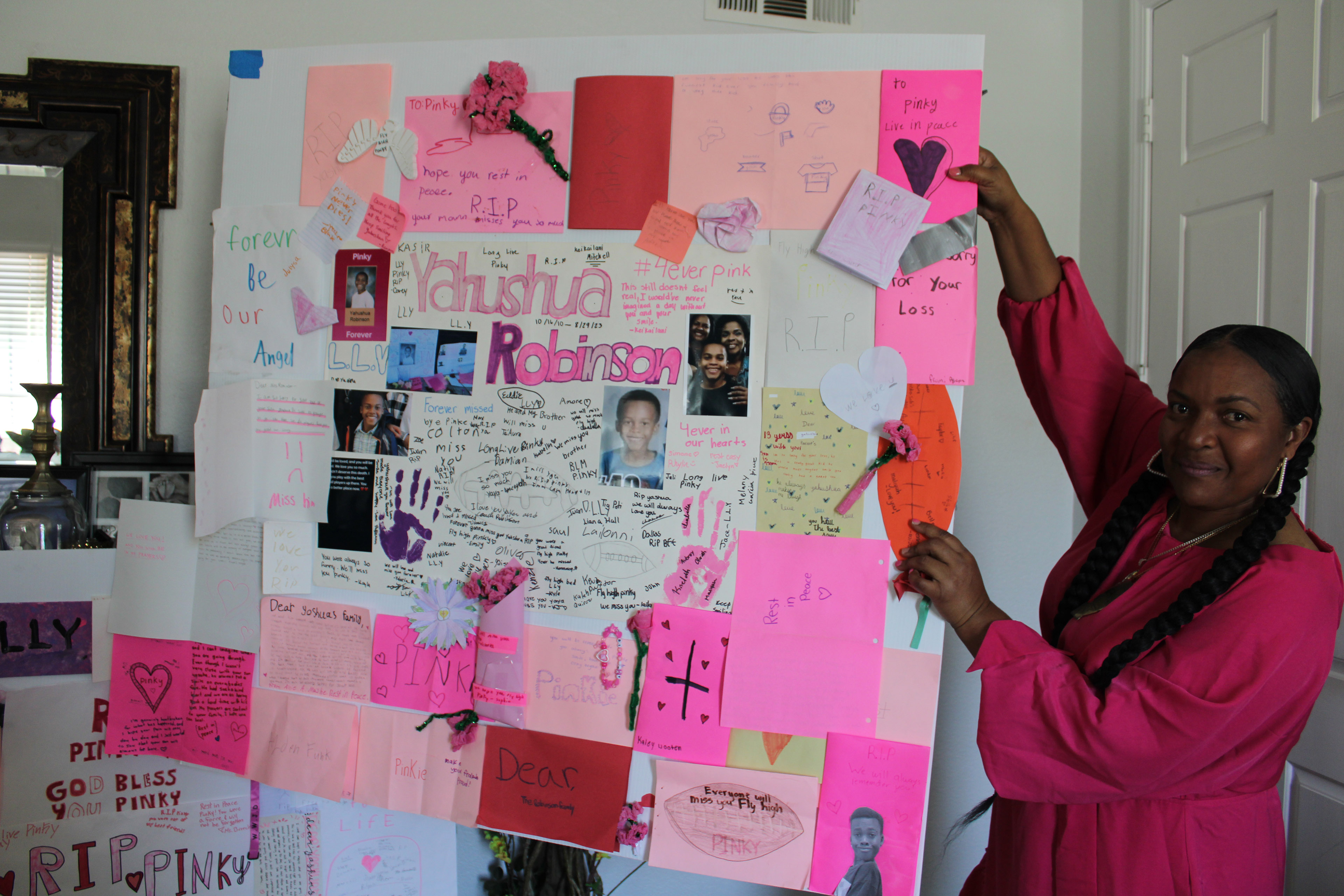 Janee Robinson holds up a poster board full of messages and cards that was given to the family after the passing of Yahushua Robinson.