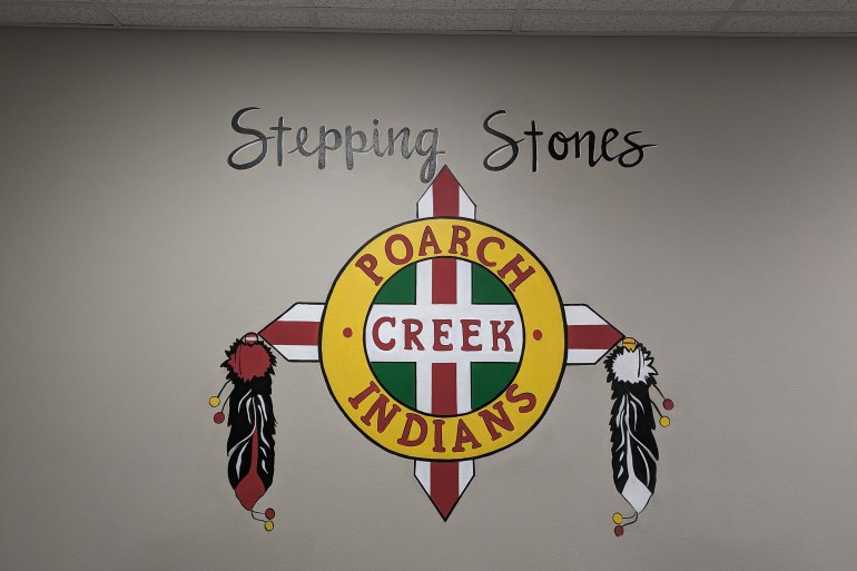 A colorful sign is painted on an interior wall that reads "Stepping Stones" and "Poarch Creek Indians".