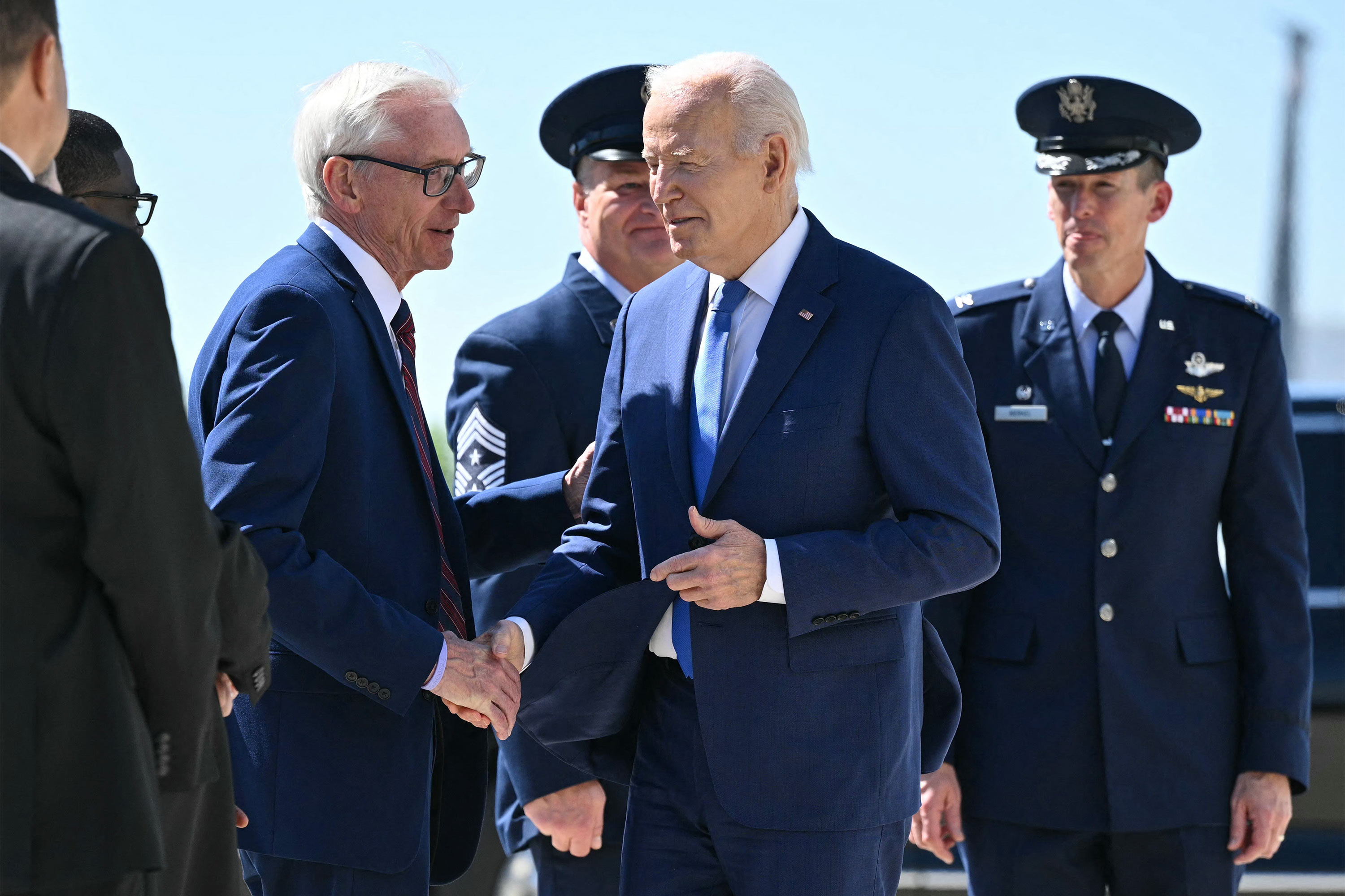 A photo of a man shaking hands with President Biden outside of Air Force One.