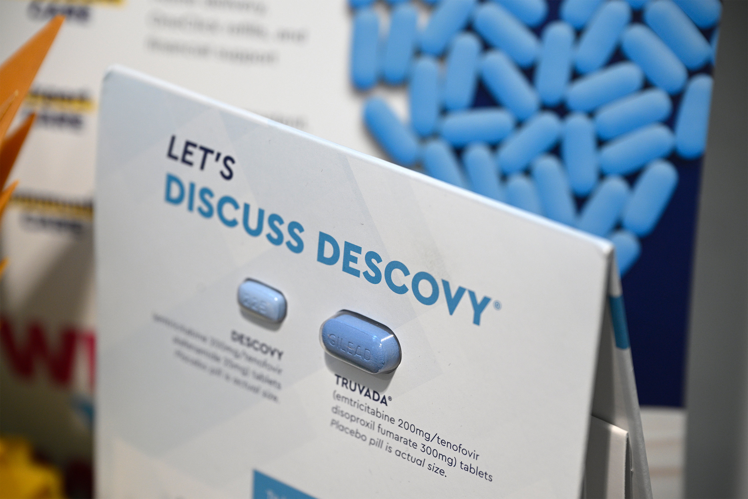 A small sign resting on a table shows information about Descovy and Truvada.