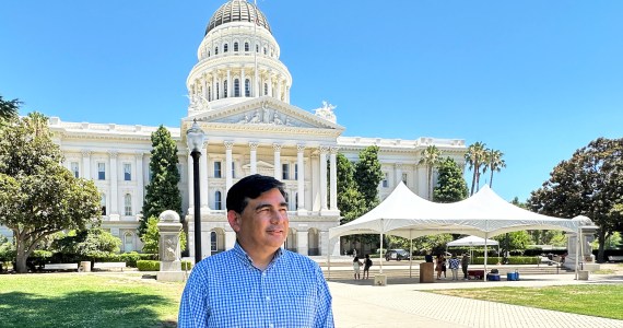 A photo of a man standing outside California's capitol.